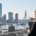 Twee vastgoedprofessionals bespreken de waarde van commercieel vastgoed met uitzicht op de skyline van Rotterdam.